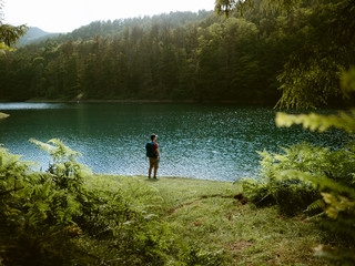Fototapeta na wymiar Young hiker contemplating the landscape in a lake