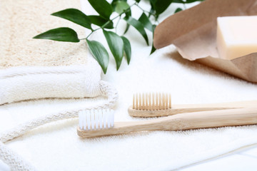 Bamboo toothbrushes with towel, soap and green leafs