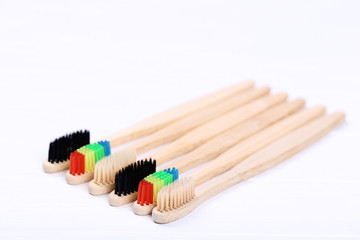 Bamboo toothbrushes on white wooden table