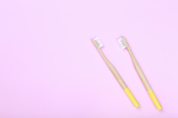 Bamboo toothbrushes on pink background