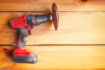 One power tool with a sander is laying on a wooden surface