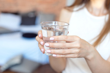 Fototapeta na wymiar Female hands holding a clear glass of water.A glass of clean mineral water in hands, healthy drink