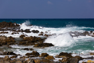 Fototapeta na wymiar sea waves beating on the rocks near the shore, white sea foam waves against the turquoise sea