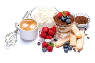 Classic tiramisu dessert with blueberries and raspberries in a glass, savoiardi and mascarpone cheese isolated on a white with clipping path