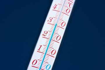 Thermometer during hot weather with sky in background