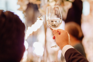 Character Guest Hold Wineglass at Wedding Ceremony. Sommelier Man Back in Classical Black Suit...