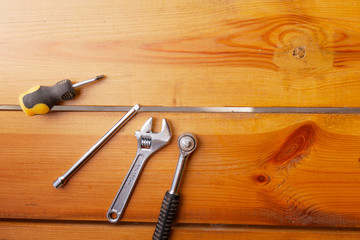 A various assortment of tools is laying on a wooden surface