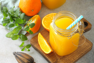 Refreshing juice made of orange, cold drink on a stone or slate background. Concept fresh vitamins. Rustic style.
