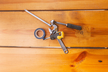 A various assortment of tools is laying on a wooden surface