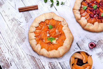 Shortbread galette with apricots topped with mint on the white wooden table