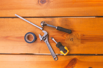 A various assortment of tools is laying on a wooden surface
