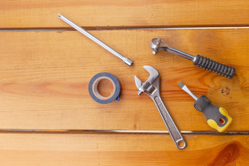 A various assortment of tools is laying on a wooden surface