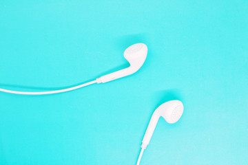 white headphones close up on a turquoise background, headphones for listening to music, modern gadgets, youth accessories