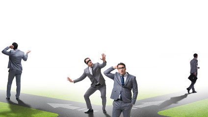 Young businessman at crossroads in uncertainty concept