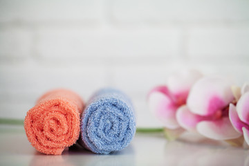 Obraz na płótnie Canvas Fluffy bath towels with natural spa ingredients with orchid flowers