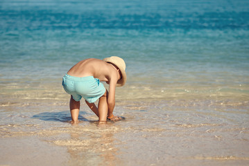European boy at the sea cost. He is enjoying his summer vacations.