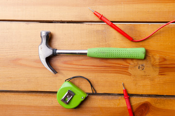 An assortment of tools are laying on a wooden surface