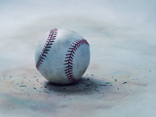 Fototapeta na wymiar Worn and dirty baseball on vintage softly colored organic canvas background