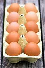 Fresh eggs on a wooden table with copy space, vertical