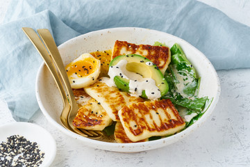 keto ketogenic diet soft boiled eggs with avocado and lettuce on pastel background closeup