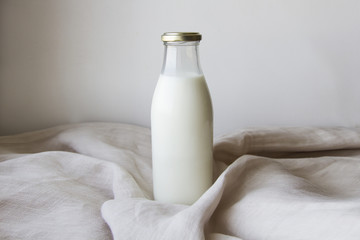 A bottle of milk in a glass bottle on a linen piece of material