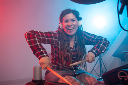 Music and hobby concept - woman drummer playing the electronic drum set