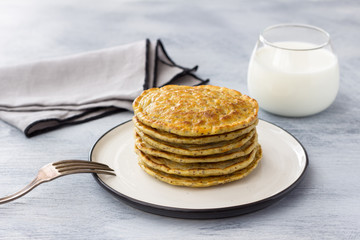Vegan pancakes with flax seeds and vegan milk on a white plate on a gray background. delicious homemade healthy food