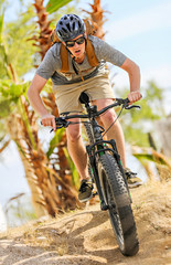Plakat Young man riding a mountain bike face on. 