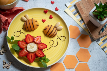 Pancake with fruits look like a flower and bees for kids breakfast