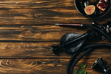 top view of hookah and exotic fruits on wooden surface