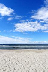 The sea is divided by a sandy beach with a beautiful view of the sky, the background