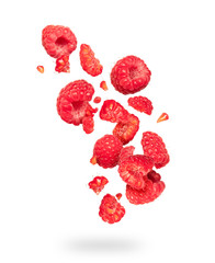 Whole and sliced raspberries in the air on a white background