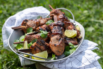 Grilled pork kebab shashlik with lime and cilantro