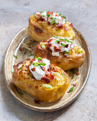 Baked loaded potato with bacon, cheese, sour cream and onion