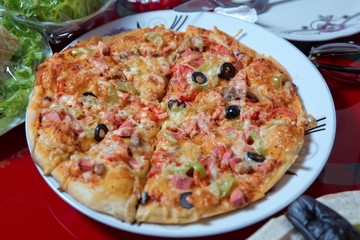 Egg, black olives, tomatoes, peppers and sausages. Cooked pizza in the plate .Delicious pizza with cheese on white plate .Pizza Margherita just mozzarella . Pizza.