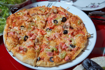 Egg, black olives, tomatoes, peppers and sausages. Cooked pizza in the plate .Delicious pizza with cheese on white plate .Pizza Margherita just mozzarella . Pizza.