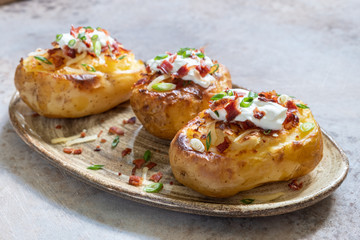 Baked loaded potato with bacon, cheese, sour cream and onion