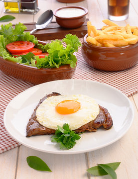 Beef steak (Bife a Cavalo) - Brazilian traditional food Steaks, White rice, farofa and salad