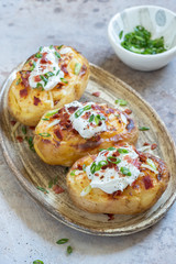 Baked loaded potato with bacon, cheese, sour cream and onion