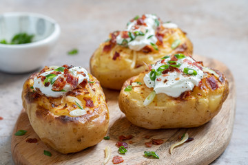 Baked loaded potato with bacon, cheese, sour cream and onion