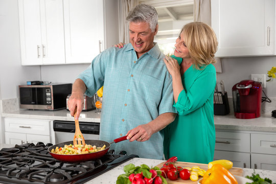 Mature, Husband And Wife, Family Cooking Vegetarian Vegetable Based Meal, With Fresh Garden Organic Ingredients