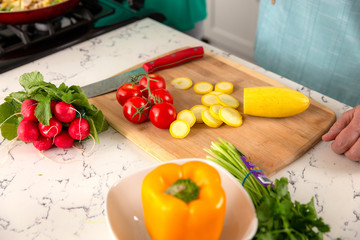 Close up of fresh garden vegetables on cutting board, tomatoes, bell pepper, zucchini and other veggies