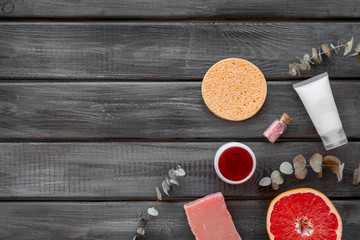 Organic cosmetics with herbs on gray wooden background top view mockup