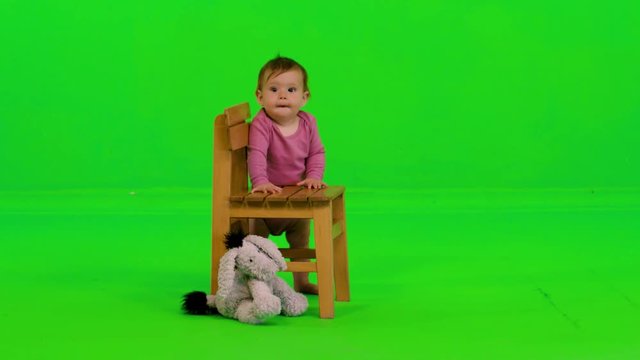 Laughing happily while standing by a cute baby girl over a green screen.