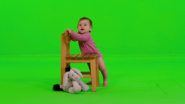 Listening and then laughing happily while standing by a cute baby girl over a green screen.
