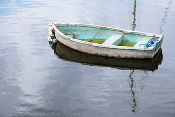 Single lonely boat sinking in water and reflection