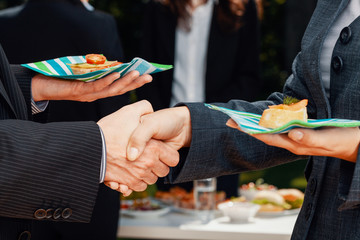 Business people shaking hands after making deal during business lunch