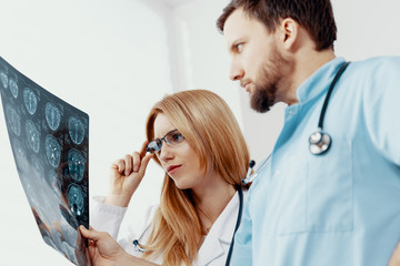 Young female doctor and handsome male nurse looking at x-ray exam