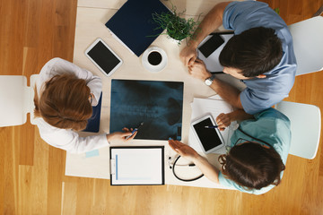 Top view of common desk with x-ray exam and notes at medical office