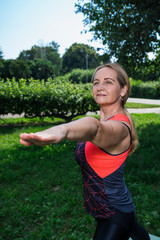 50 years old woman practice yoga outdoor.